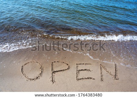 Word Open is written in the sand on the beach for the tourists, after the coronavirus pandemic, sea holidays are possible again, selected focus