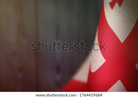 Georgia hanging flag for honour of veterans day or memorial day on blue blurred natural wood wall background. Georgia glory to the heroes of war concept.
