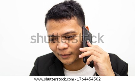 A portrait of young Asian businessman having a serious talk and conversation on the phone with isolated white background. Career business job concept.