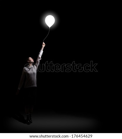 businesswoman holding flying light bulb