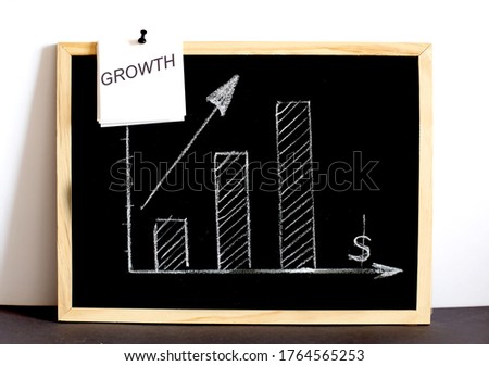 The graph shows the increase of the target drawn in chalk on the Board with text on white sticker GROWTH
