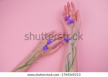 Photo of beautiful female hands with blue flowers, female body part isolated on a white background, day Spa, natural hand cosmetics, luxury beauty salon and Spa, manicure and massage concept