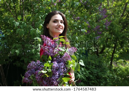 portrait Summer beauty smiling girl with long black hair in a good spring mood in flowers
