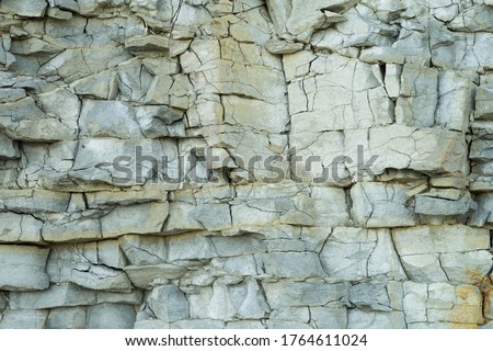 Fragment of natural limestone cliff in Kesselaid (also Kessulaid) islet nordic coast. Tiny island in Suur Strait, Baltic Sea Layers of cracked rocks. Texture of  hard sedimentary rock. Estonian coast. Royalty-Free Stock Photo #1764611024