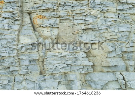 Fragment of natural limestone cliff in Kesselaid (also Kessulaid) islet nordic coast. Tiny island in Suur Strait, Baltic Sea Layers of cracked rocks. Texture of  hard sedimentary rock. Estonian coast. Royalty-Free Stock Photo #1764618236