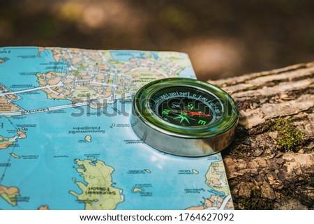 compass and map lie on a stump