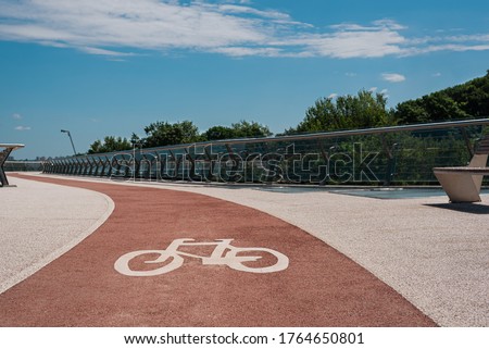 Bike path with of bicycle symbol. Pink bike lane with non-slip acrylic coating on city footbridge Royalty-Free Stock Photo #1764650801