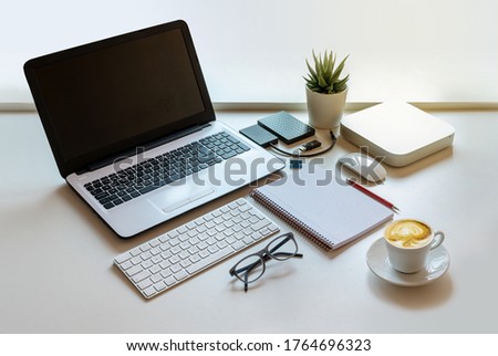 Nice and bright work space with computer equipment and coffee