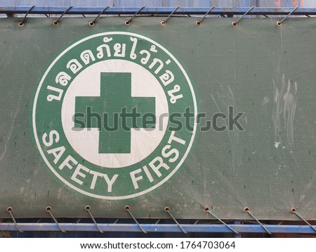 Safety symbol before dark green background The Thai language in the picture means safety first