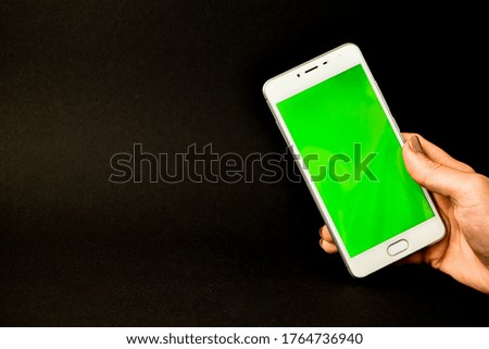 Young woman using white phone device with green screen. Woman holding phone. Chroma key. Close up. Copy space
