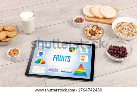 Organic food and tablet pc showing FRUITS inscription, healthy nutrition composition