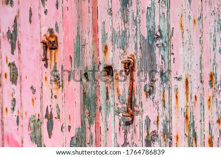 Heavily weathered wooden doors with layers of peeling paint.