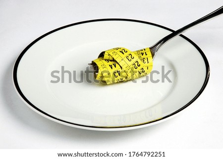 Measuring Tape and Fork on Plate on white background 
