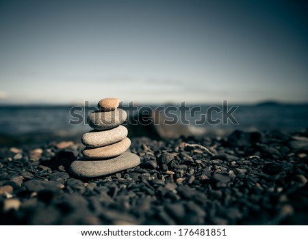 Stack of zen stones on beach. Selective focus and shallow depth of field. Color toned image.