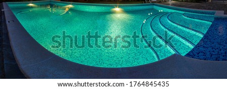 Pool at night with pure blue water background. Top view of swimming pool and floor texture Panorama of pool bottom with tile pattern and transparent water Summer travel and vacation background concept