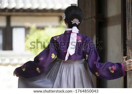 Woman in Korean traditional clothes standing at traditional Korean house
 Royalty-Free Stock Photo #1764850043