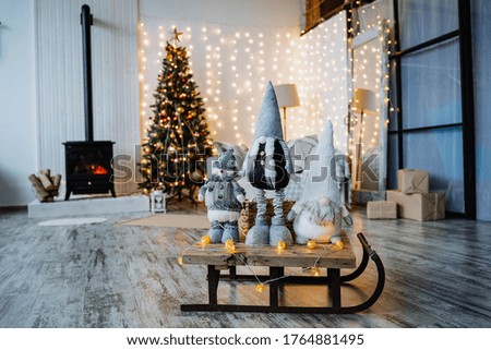 gnomes on the background of Christmas decorations, bearded little men, Christmas toys in the room on the table, evening light, noise in the photo, selective focus