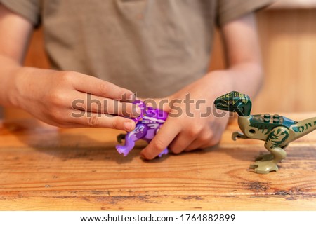 
Little boy plays with toy dinosaurs