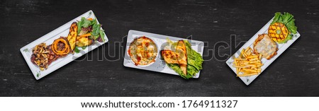 Food cooking background on black chalk table top view. Flat-lay of  Fricassee, Steak and Burger on black background. Long banner format 8720x2648. Great image banner for websites or other projects.  Royalty-Free Stock Photo #1764911327