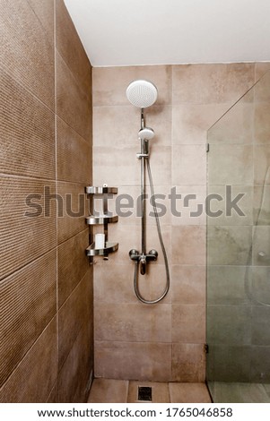 Shower cabin with beige wall tile