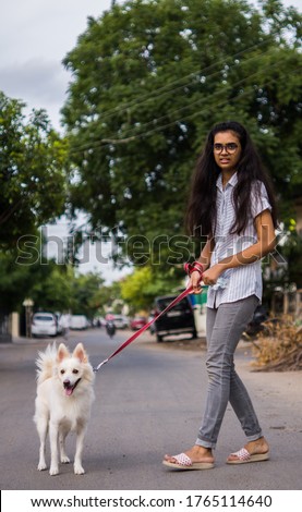 Young teenager girl took the Indian spitz dog to the walk