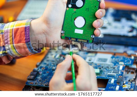 the concept of computer hardware, mobile phone, electronic, repairing, upgrade and technology, vacuum cleaning of the cooler from dust,