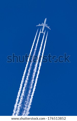 A long trail of jet plane on blue sky Royalty-Free Stock Photo #176513852