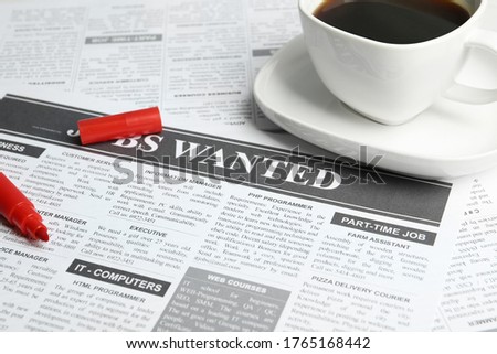 Cup of coffee and marker on newspaper. Search concept