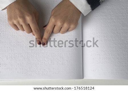 Blind woman reading text in braille language