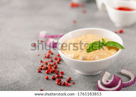 Thousand Islands sauce and ingredients - cucumbers, onions, paprika, ketchup and mayonnaise in bowls on the table. American cuisine, dip for burgers and meat. Royalty-Free Stock Photo #1765183853