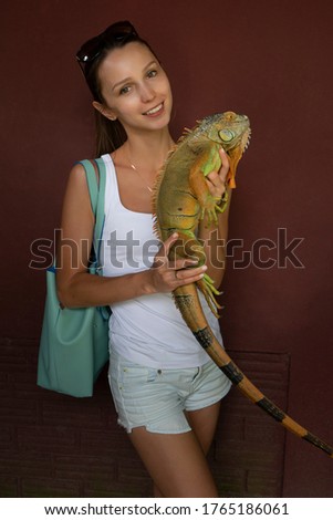 Girl holds a beautiful lizard in her hands