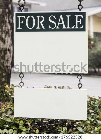 Real estate sign with drops of water hanging in front yard, with white copy space for your message and sub-message (shallow depth of field)