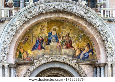 St Mark`s Basilica or San Marco closeup, Venice, Italy. It is top landmark in Venice. Beautiful Christian mosaic portal with image of Christ. Detail of ornate facade of old famous St Mark`s cathedral.