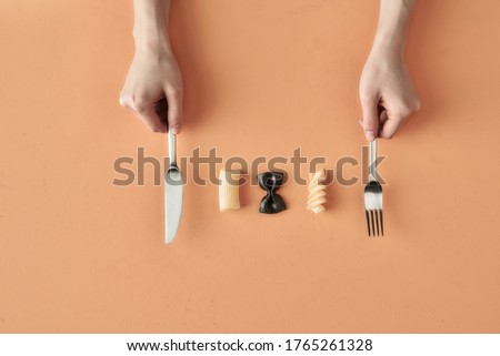 Farfalle, tortiglioni and fusilli pasta and hands with fork and knife, photography for food blog or advertising