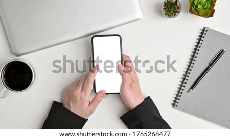 hand businesswoman using a telephone, blank screen smart phone, laptop, notebook and coffee cup on white table top view.