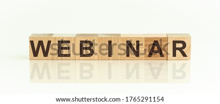 WEBINAR word written on wood block. The text is written in black letters and is reflected in the mirror surface of the table. Text on white table for your desing, concept.