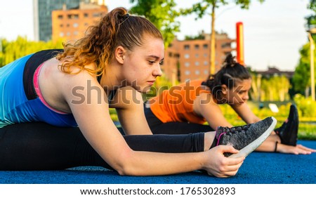 young girls stretching in a city park in the morning 