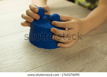 Child playing with kinetic sand.