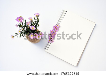 Workplace top view, flat lay, office desk table, empty spiral notebook, violet daisy flowers composition, European Michaelmas Daisy, business background, studying memory concept Royalty-Free Stock Photo #1765379615
