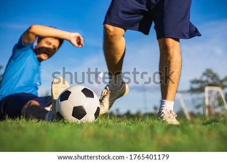 Action sport outdoors of boys having fun playing soccer football for exercise in community rural area on the green grass field. Picture for sport player and health recreation concept.