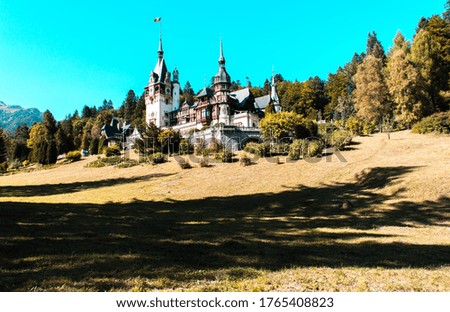 Peles Castle, Sinaia, Romania. The residence of the royal family of Romania. Ornamental garden and royal palace. Green trees and blue sky  on background  