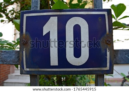 A house number plaque, showing the number ten (10)
