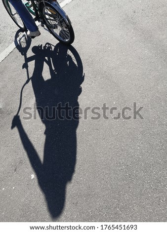 Texture asphalt background with shadow bicyclist on sunny summer day