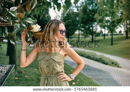 the girl sniffs a Magnolia