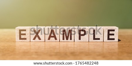 EXAMPLE word written on wooden blocks on wooden table. Concept for your design Royalty-Free Stock Photo #1765482248