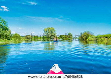 Kayak trip on blue river landscape and green forest with trees blue water clouds sky