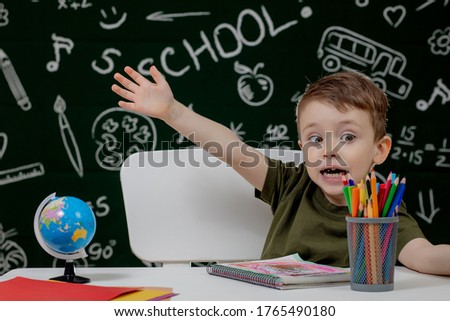 Cute child boy doing homework. Clever kid drawing at desk. Schoolboy. Elementary school student drawing at workplace. Kid enjoy learning. Home schooling. Back to school. Little boy at school lesson.
