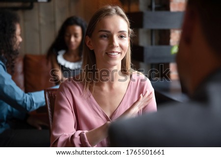 Speed dating, sympathy, flirtation, search partner and love concept. Young woman sitting in cafe participates in matchmaking event activity telling about herself enjoy communication with rear view guy Royalty-Free Stock Photo #1765501661