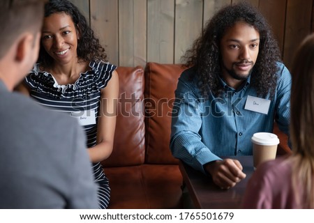Two multi ethnic couples African and Caucasian potential partner, love seeker, participating in speed dating meeting, romantic activity interact in cafe. First impression, flirtation, sympathy concept Royalty-Free Stock Photo #1765501679