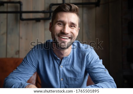 Head shot portrait smiling Caucasian man sitting indoors having pleasant web cam videoconference on-line chat by work or informal speak use pc. Job interview, tutoring video call, modern tech concept Royalty-Free Stock Photo #1765501895